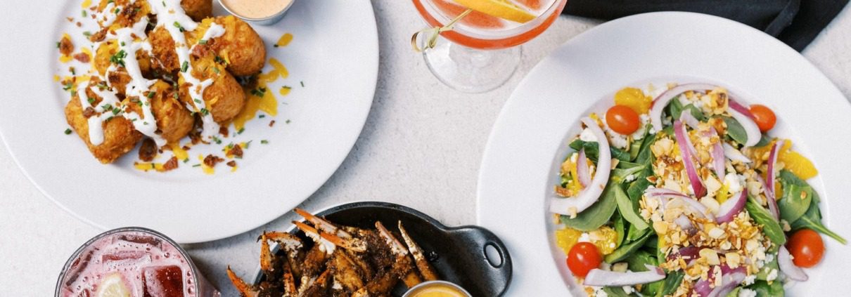 A delicious spread of crab claws, salad, and drinks