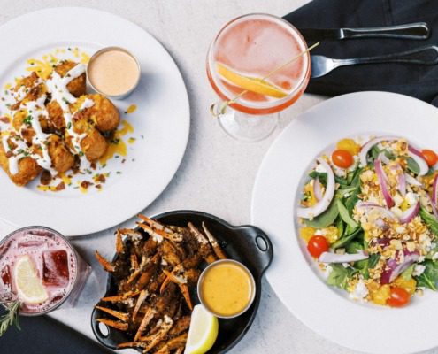 A delicious spread of crab claws, salad, and drinks