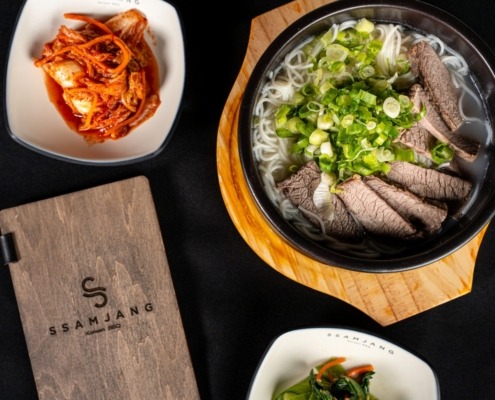 Table with plates of food from SsamJang Korean Barbecue