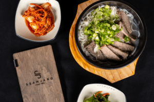 Table with plates of food from SsamJang Korean Barbecue