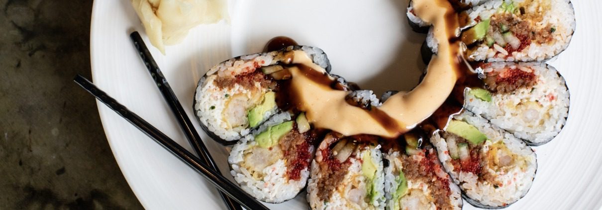 Arial view of a portion of a plate of sushi with chop sticks