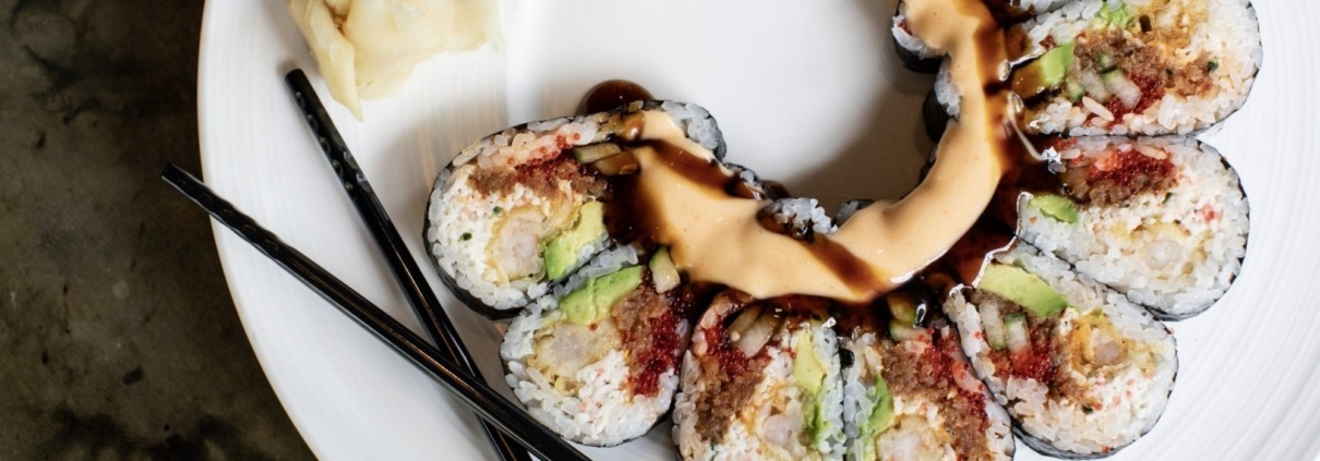 Arial view of a portion of a plate of sushi with chop sticks