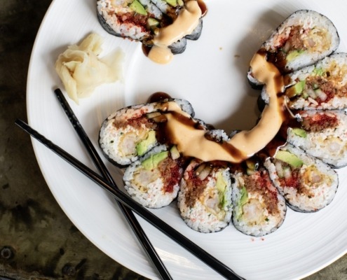 Arial view of a portion of a plate of sushi with chop sticks